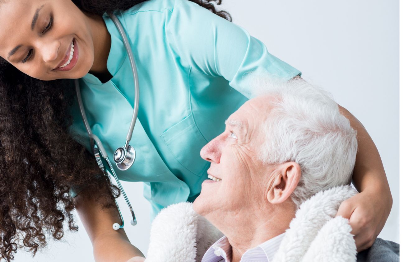 Eine Pflegekraft unterstützt einen älteren Mann, um ihm bei seinen täglichen Aktivitäten zu helfen und ihn zu betreuen.